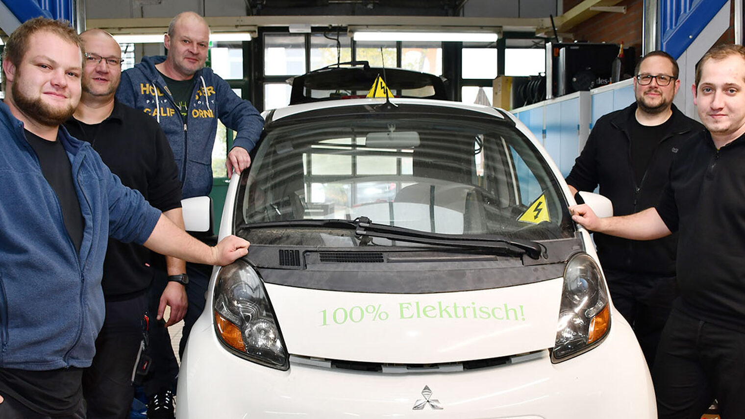Fünf Mechatroniker des Bundeskriminalamts stehen an einem Auto.