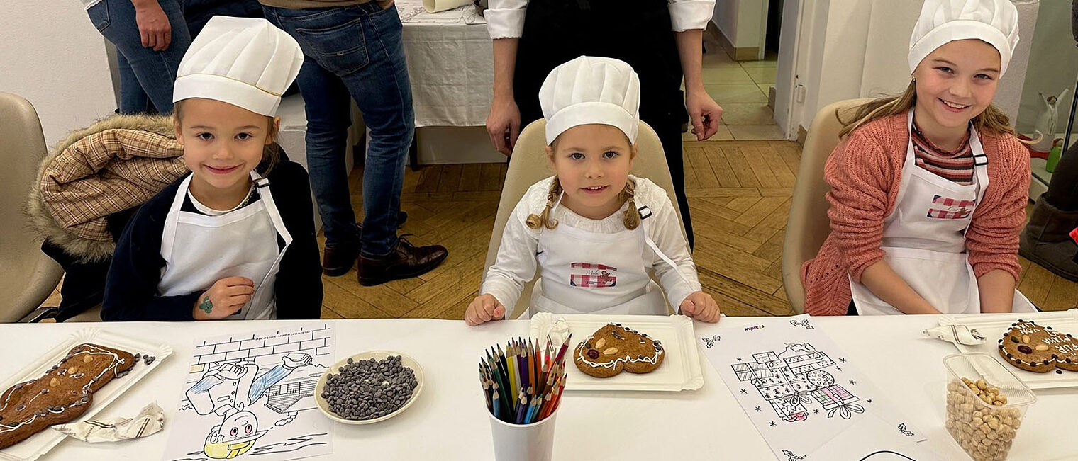 Drei Kinder sitzen am Tisch Drei Kinder sitzen am Tisch