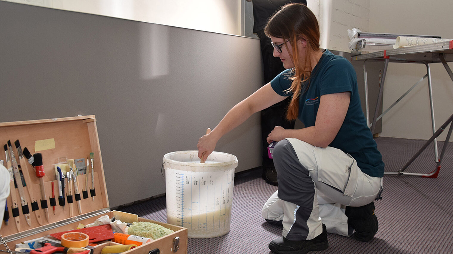 Eine Person arbeitet mit Kleber.
