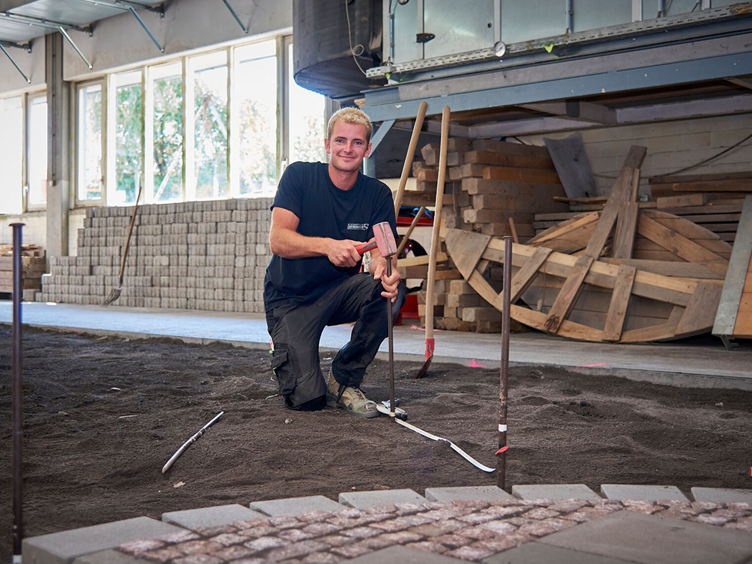 Straßenbauer Benjamin Leidig bei den Vorbereitungen zum Pflastern während des Wettbewerbs.