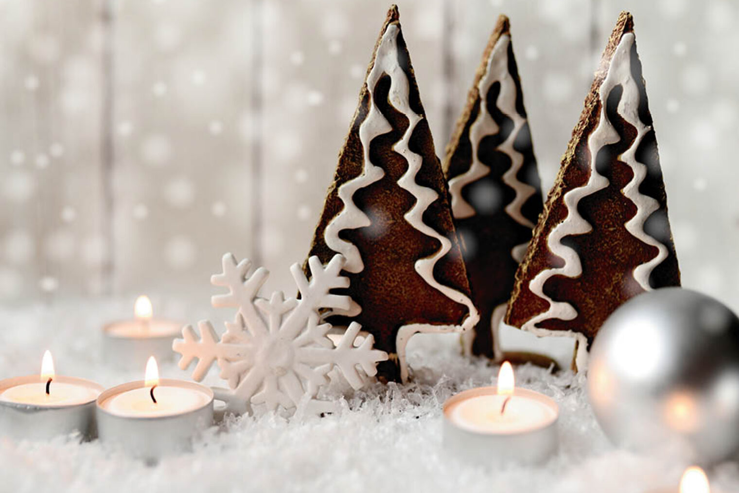 Dekoration einer Winterlandschaft Dekoration einer Winterlandschaft mit Lebkuchen-Tannenbäumen, Sternen und Kerzen