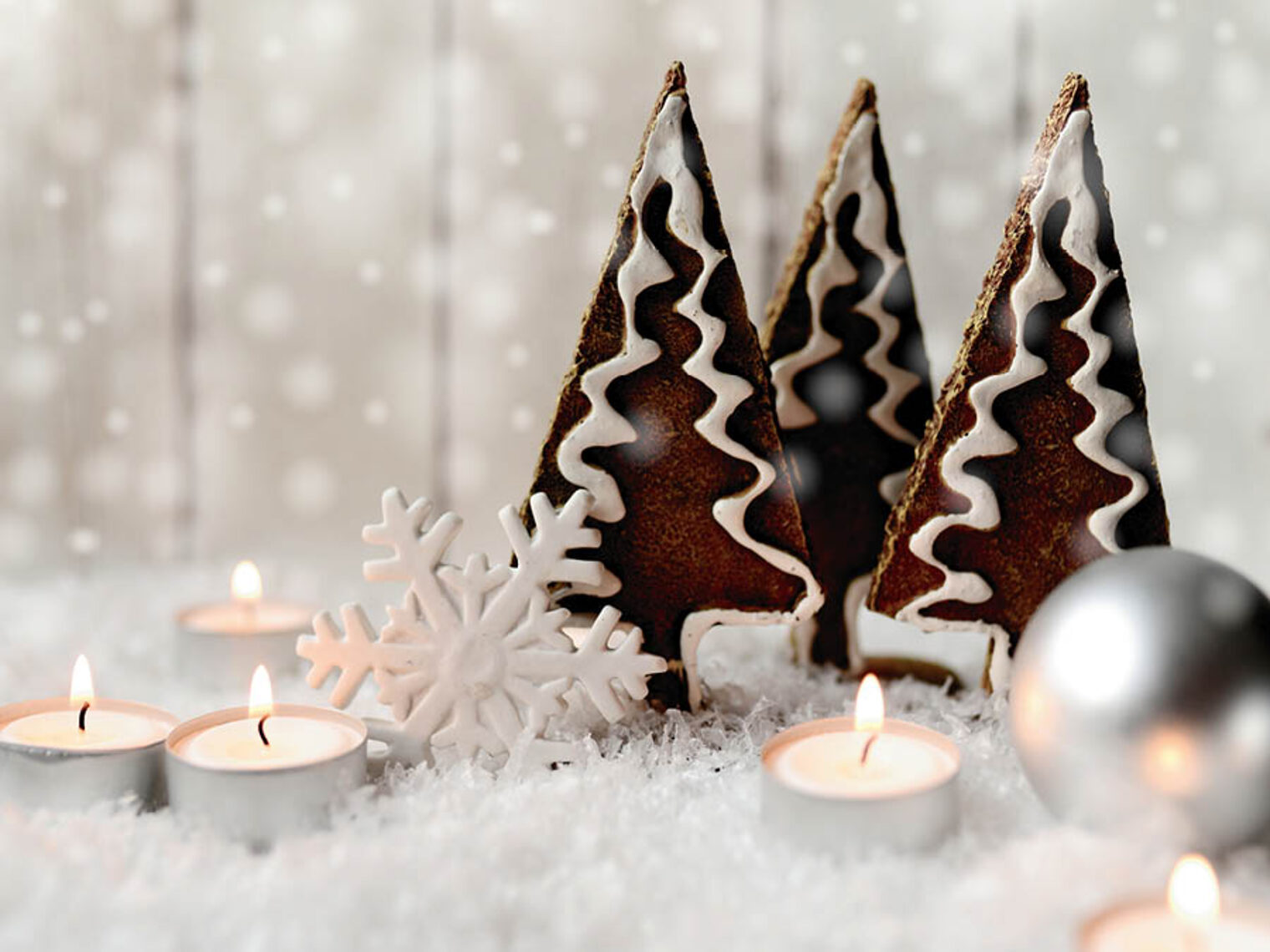 Dekoration einer Winterlandschaft mit Lebkuchen-Tannenbäumen, Sternen und Kerzen