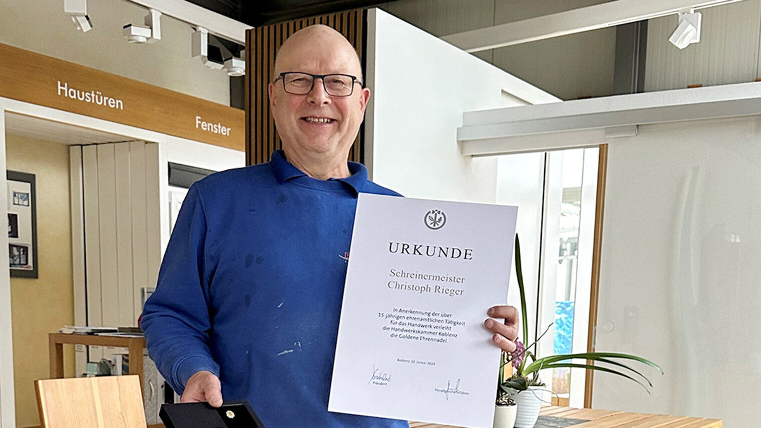 Christoph Rieger präsentiert seine Urkunde und die Goldene Ehrennadel.