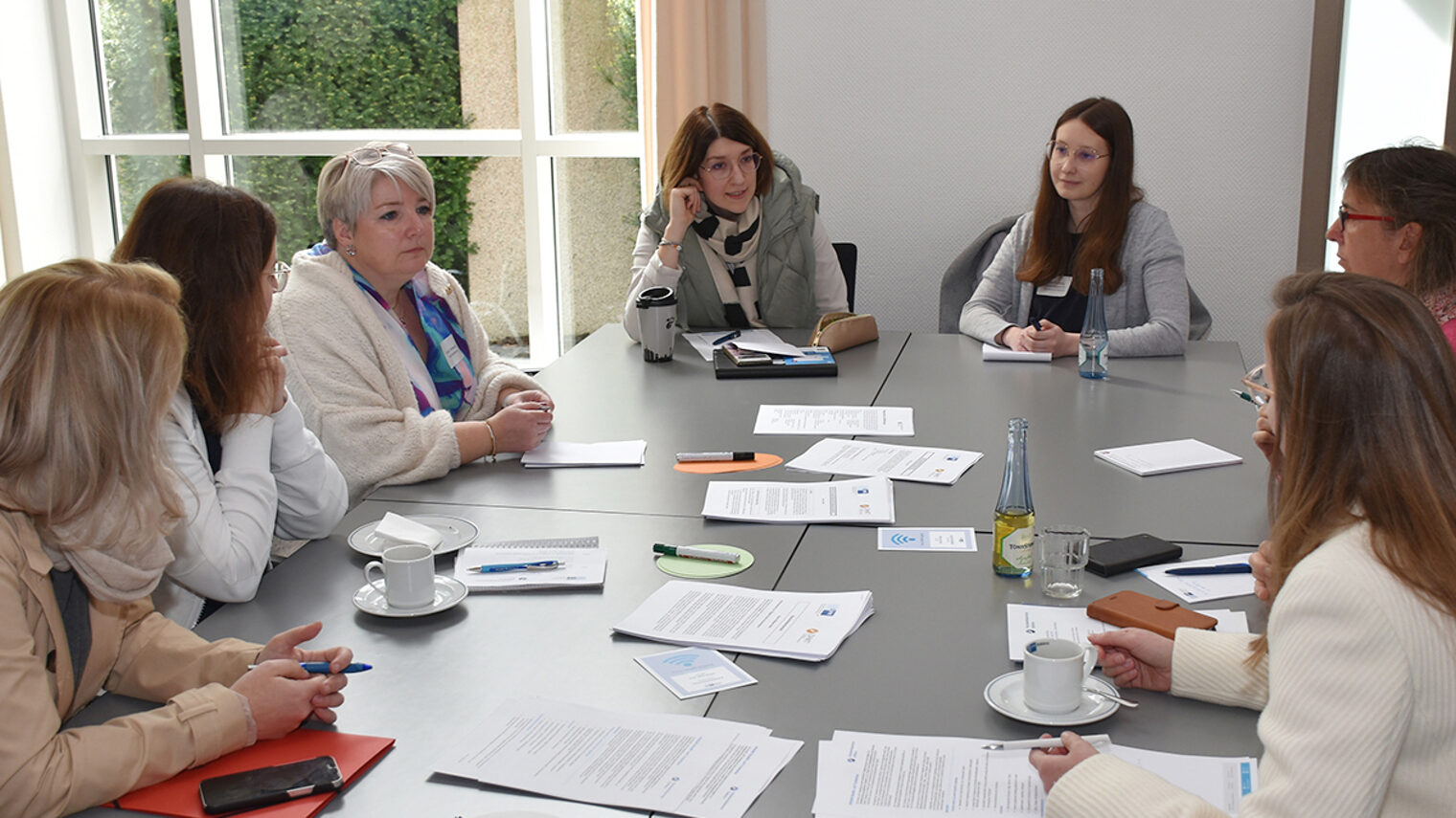 Teilnehmer der Veranstaltung sitzen an einem Tisch und besprechen sich.