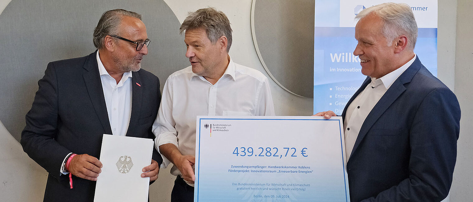 Robert Habeck überreicht Ralf Hellrich und Kurt Krautscheid einen Förderbescheid in Höhe von rund 440.000 Euro.