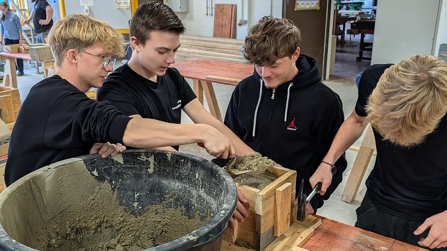 Vier Personen arbeiten mit Beton.