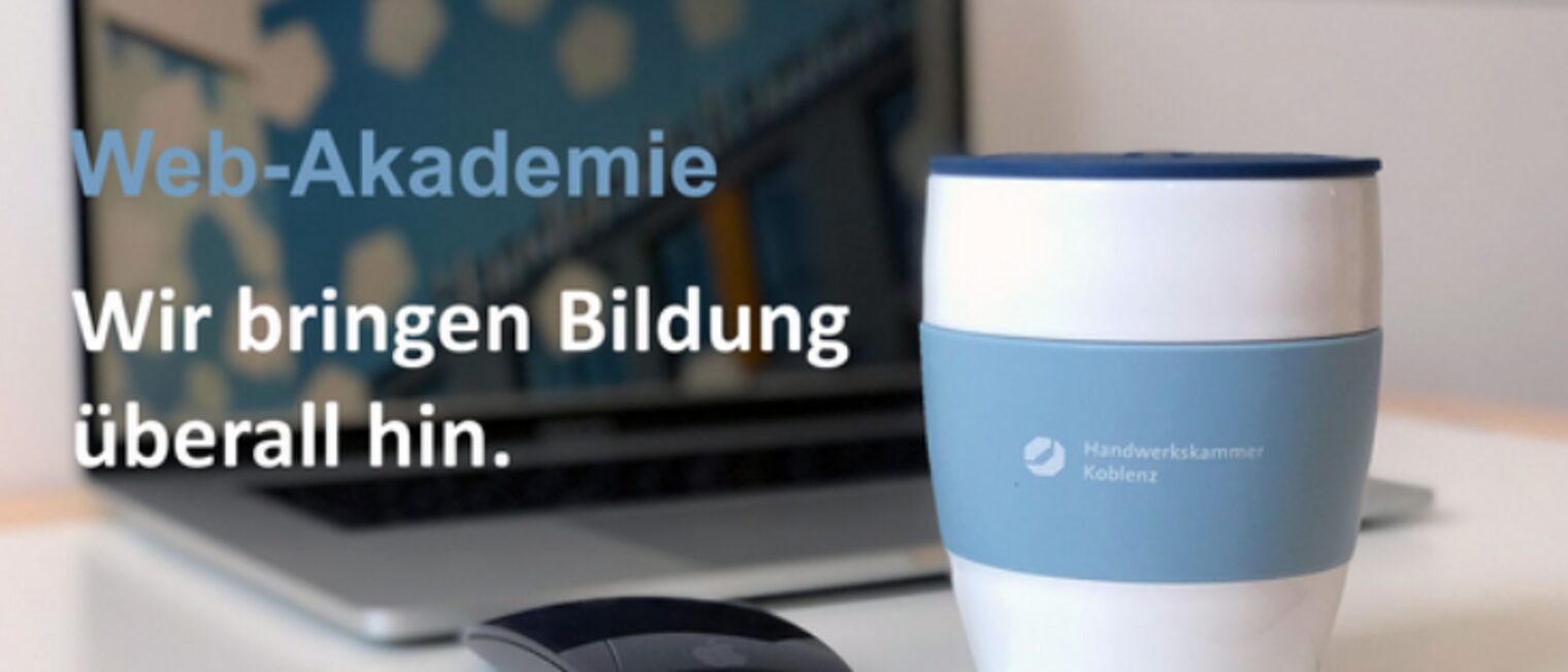 aufgeklappter Laptop und Kaffeebecher