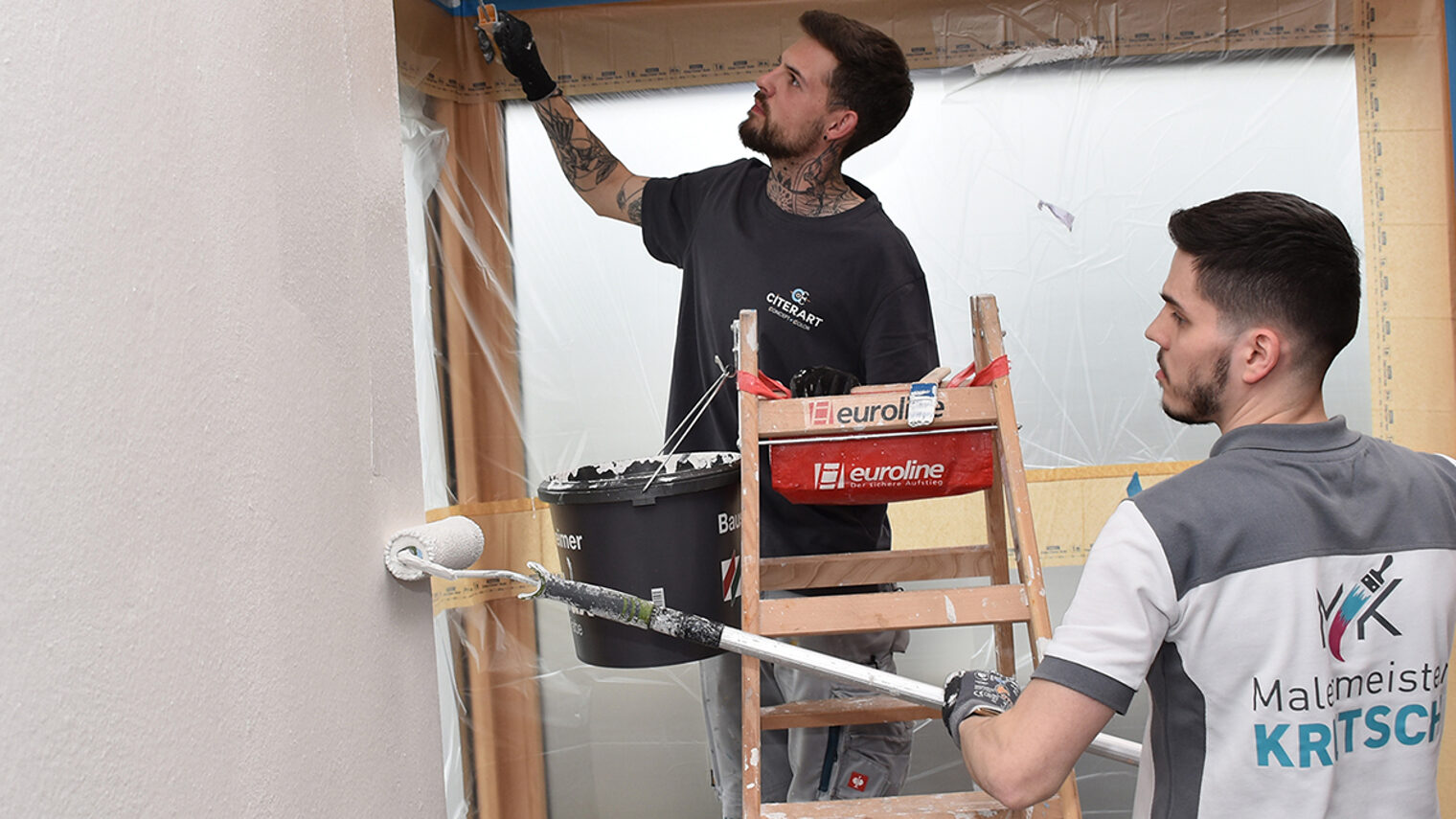 Zwei Maler streichen die Wand