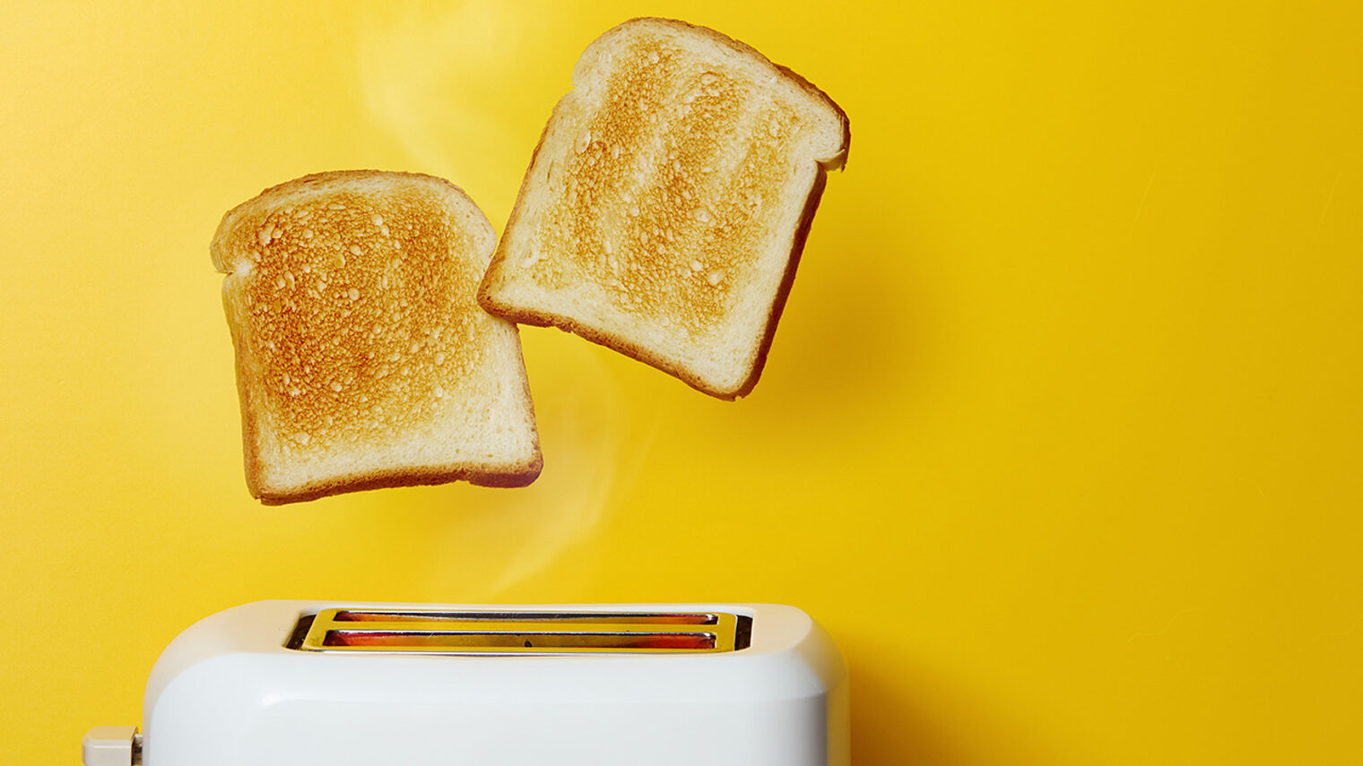 zwei Toastscheiben springen aus einem Toaster