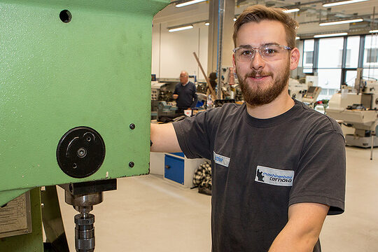 Feinwerkmechaniker Yannis Dörr arbeitet an einer Maschine.