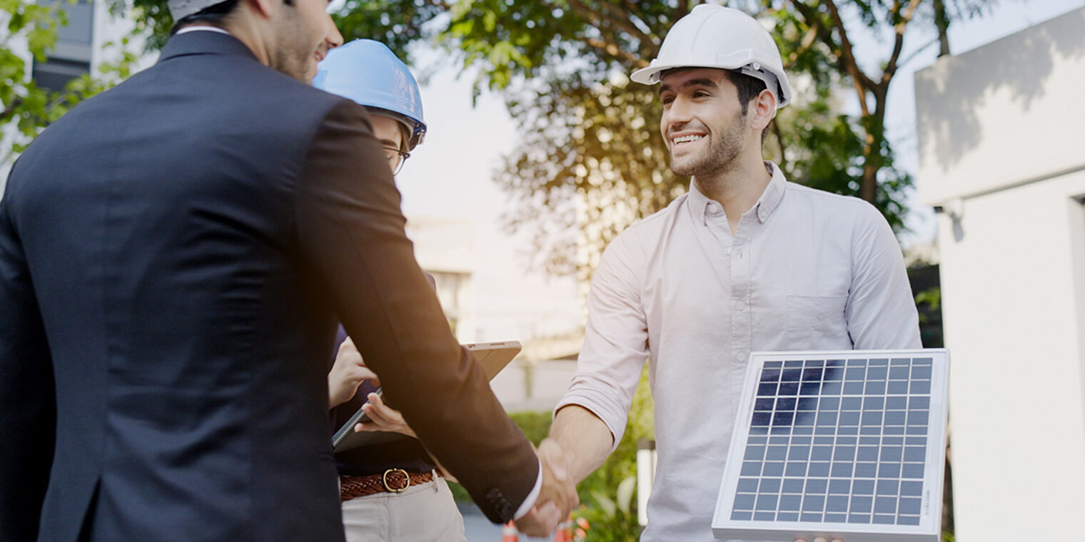 ein Gebäudeenergieberater im Beratungsgespräch mit zwei Kunden