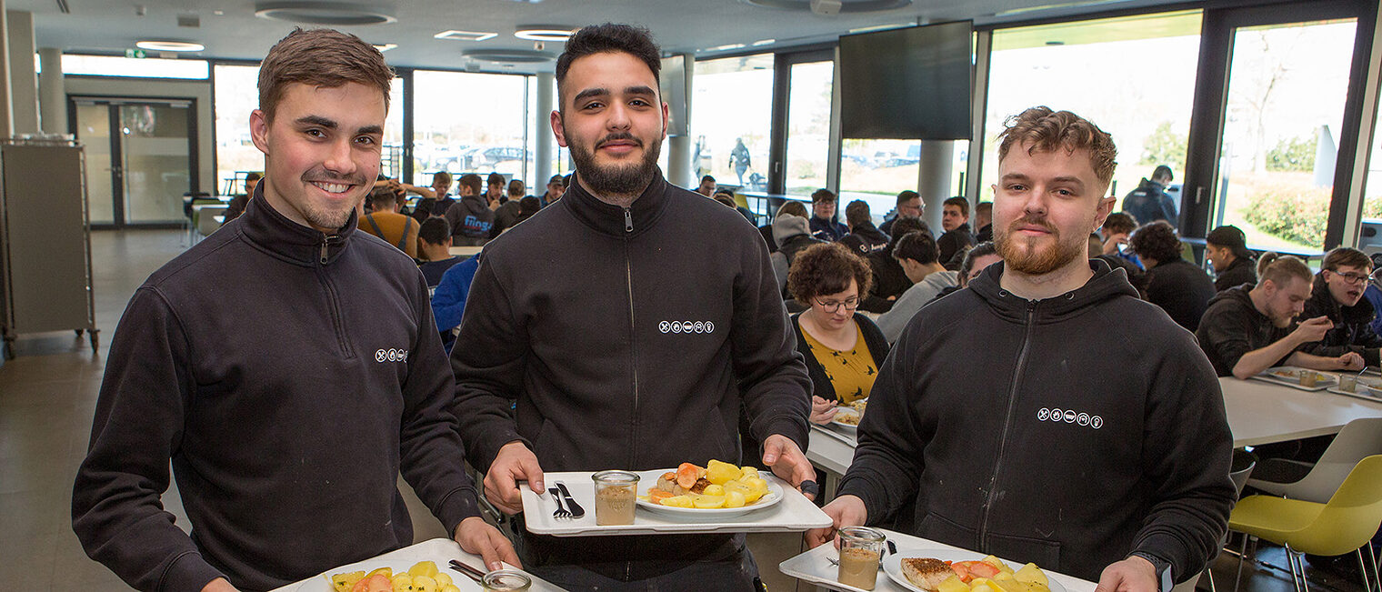 Drei Auszubildende freuen sich über das gesunde Essen in den HwK-Mensen.