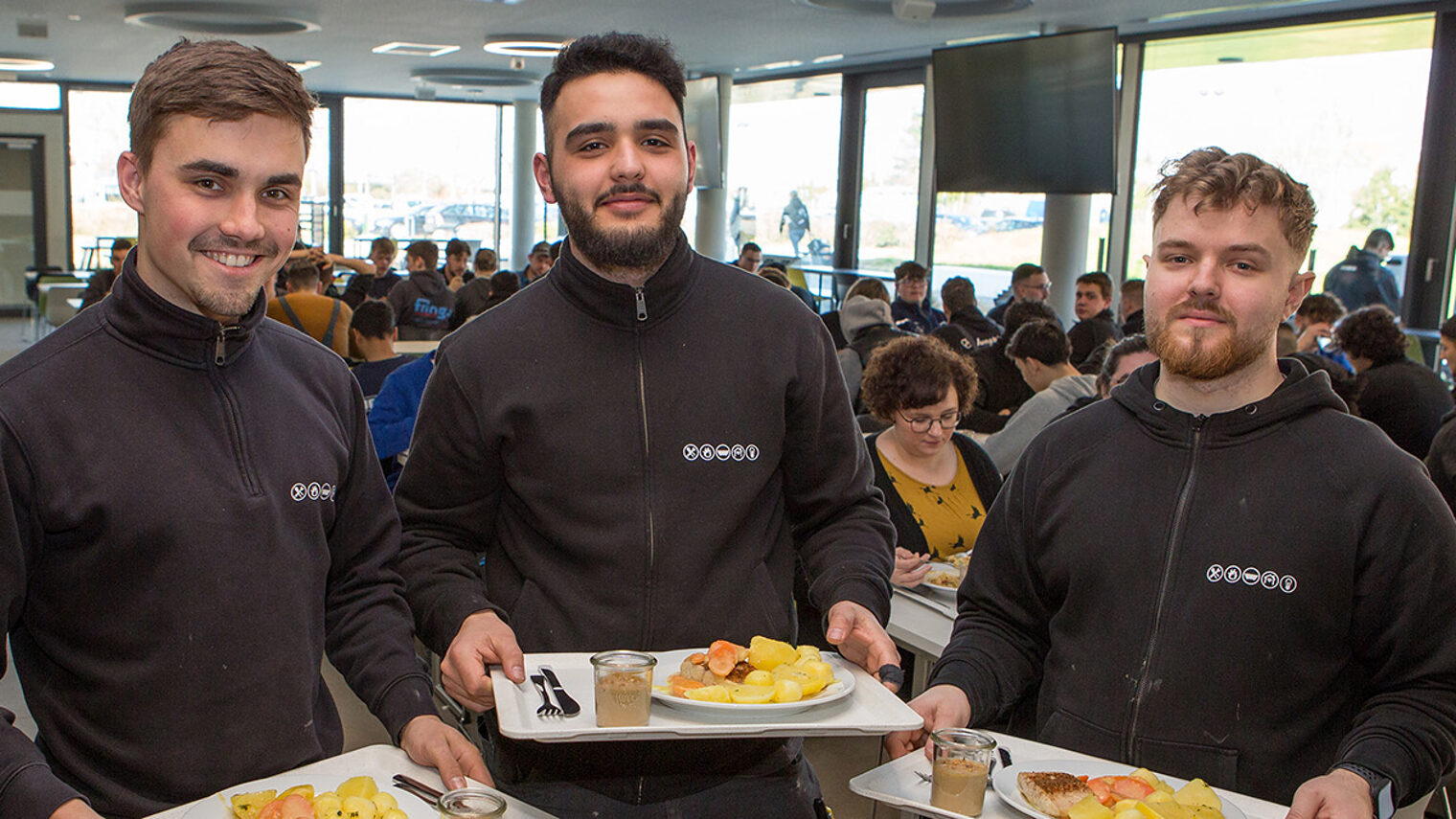 Drei Auszubildende freuen sich über das gesunde Essen in den HwK-Mensen.