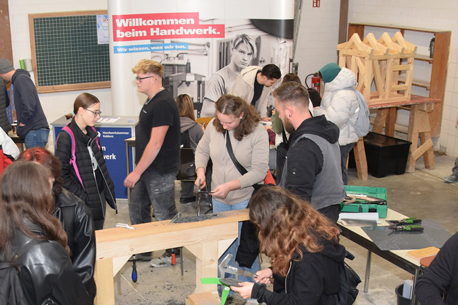 Jugendliche Besucher probieren das Schlagen von Schiefer aus.