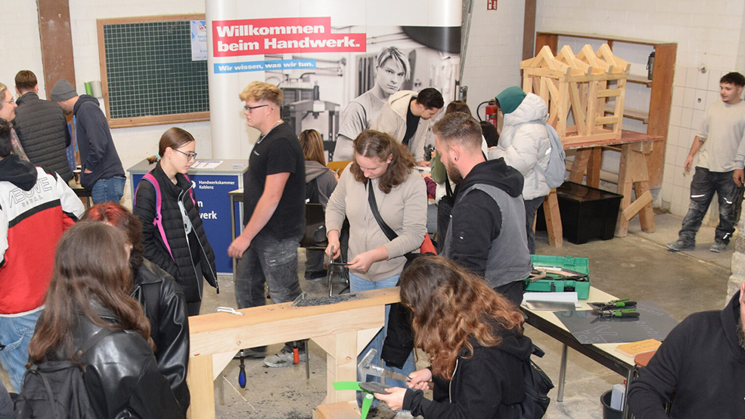 Jugendliche Besucher probieren das Schlagen von Schiefer aus.
