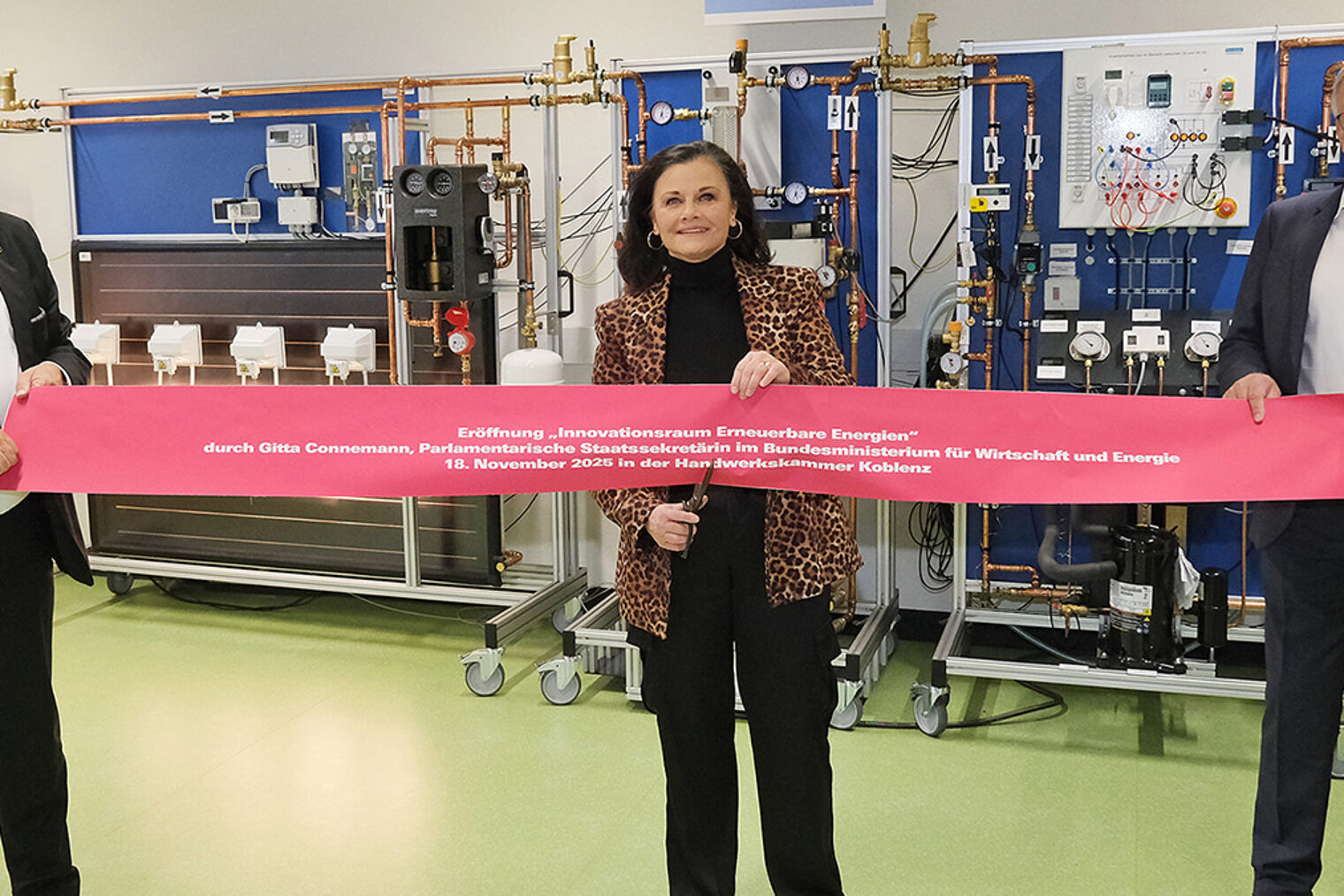 Gitta Connemann schneidet symbolisch ein rotes Band durch.