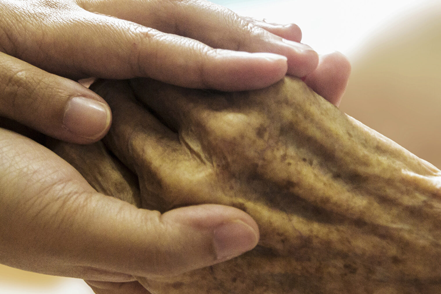 Eine Hand wird von zwei Händen umschlossen.