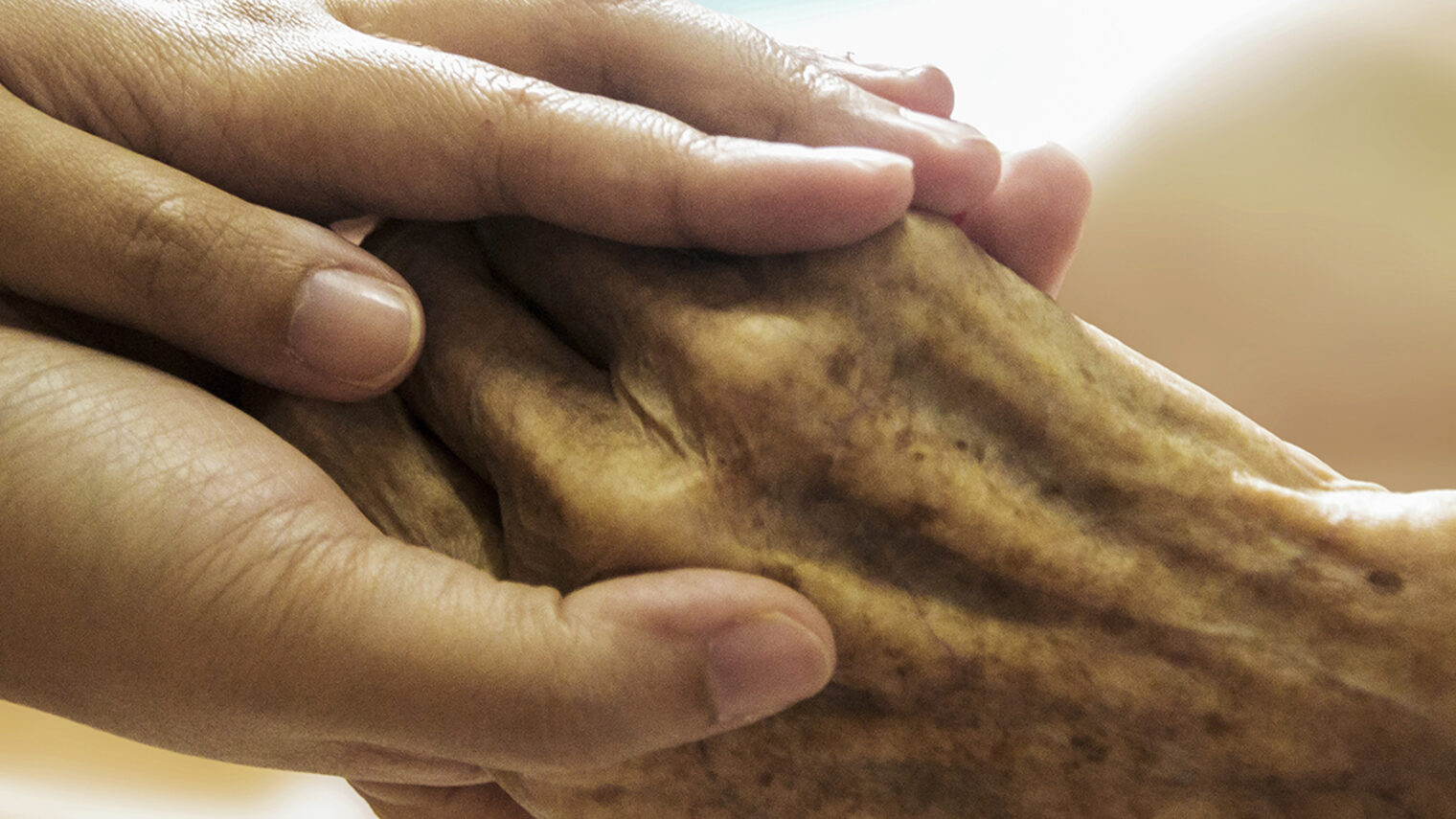 Eine Hand wird von zwei Händen umschlossen.