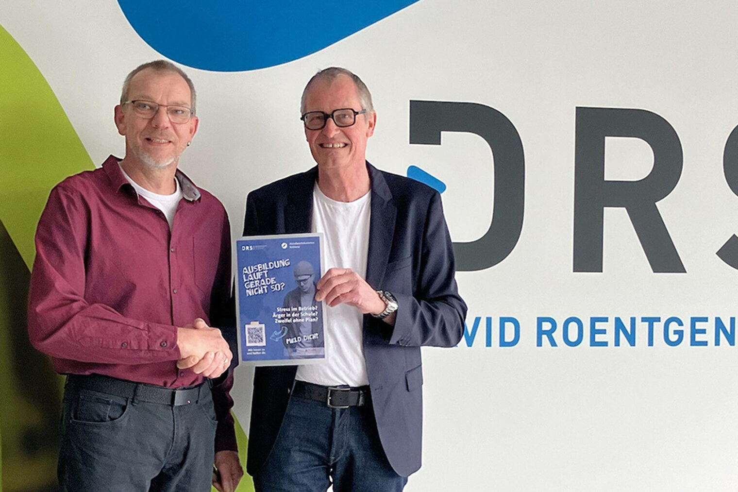 Jürgen Stein und Dirk Oswald präsentieren das neue Plakat.