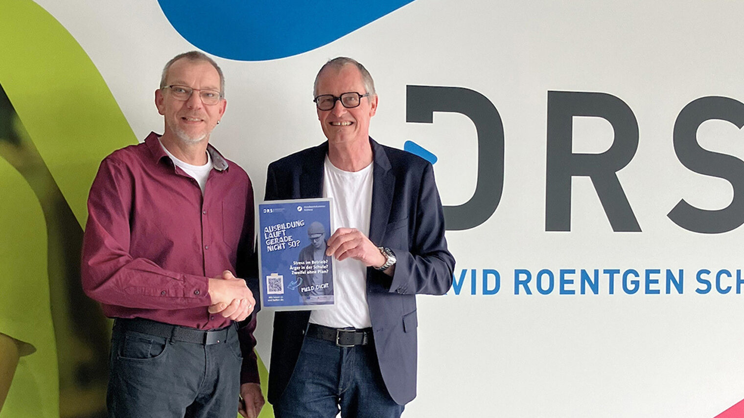 Jürgen Stein und Dirk Oswald präsentieren das neue Plakat.