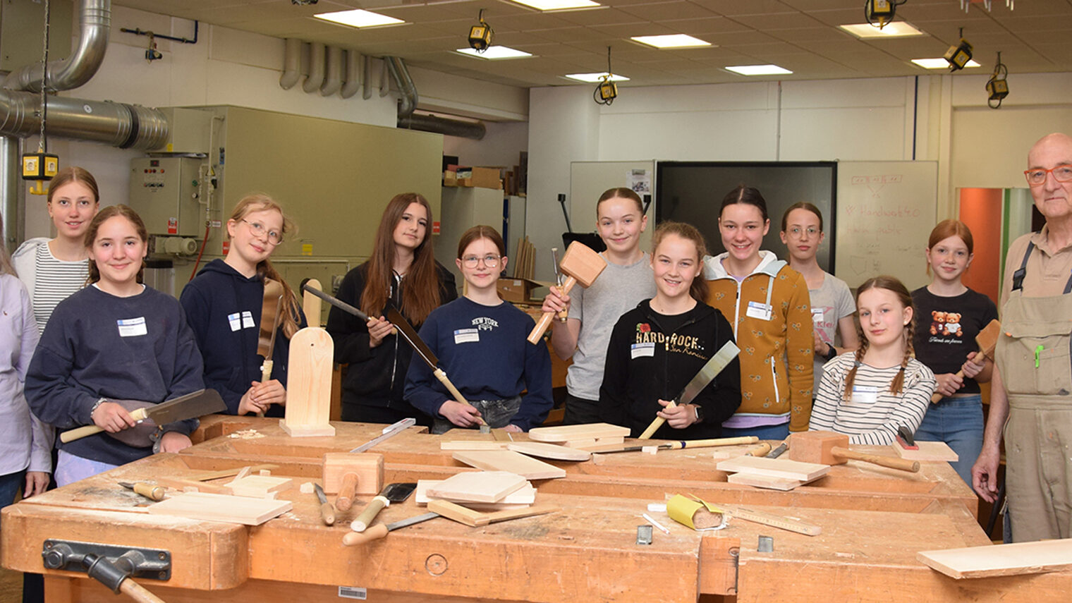 Teilnehmerinnen des Girls'Day mit dem Workshopleiter und der Ausbildungsberaterin in der Tischlerwerkstatt