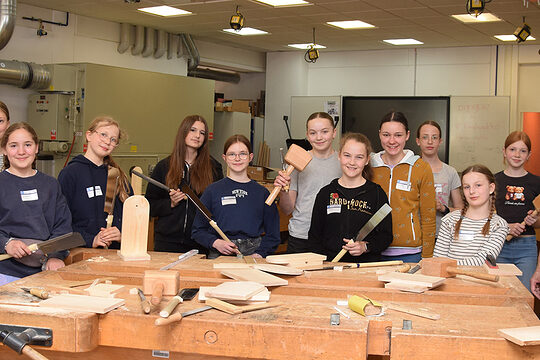 Teilnehmerinnen des Girls'Day mit dem Workshopleiter und der Ausbildungsberaterin in der Tischlerwerkstatt