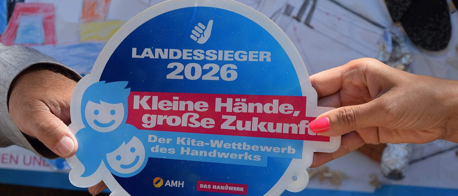 Zwei Hände halten eine Plakette