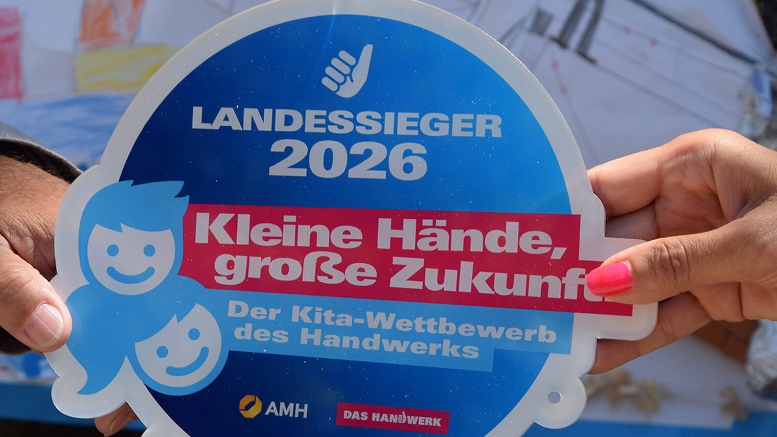 Zwei Hände halten eine Plakette
