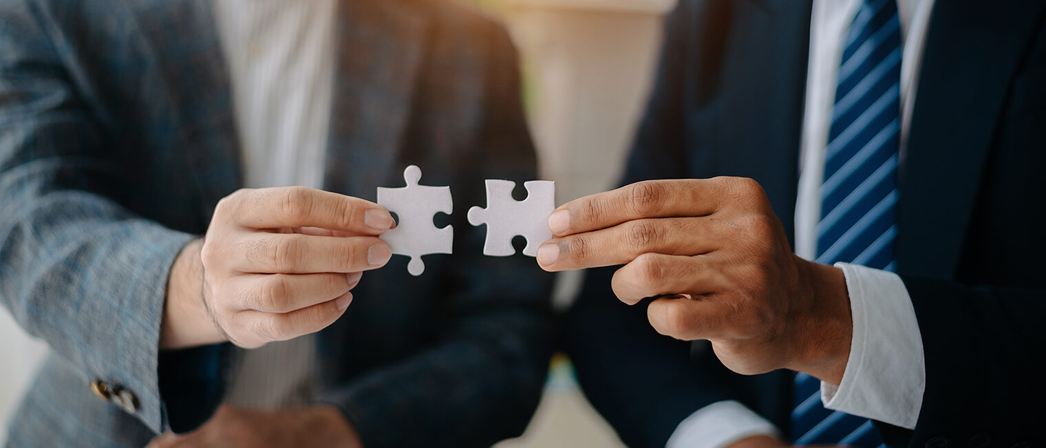 Zwei Personen fügen Puzzleteile zusammen