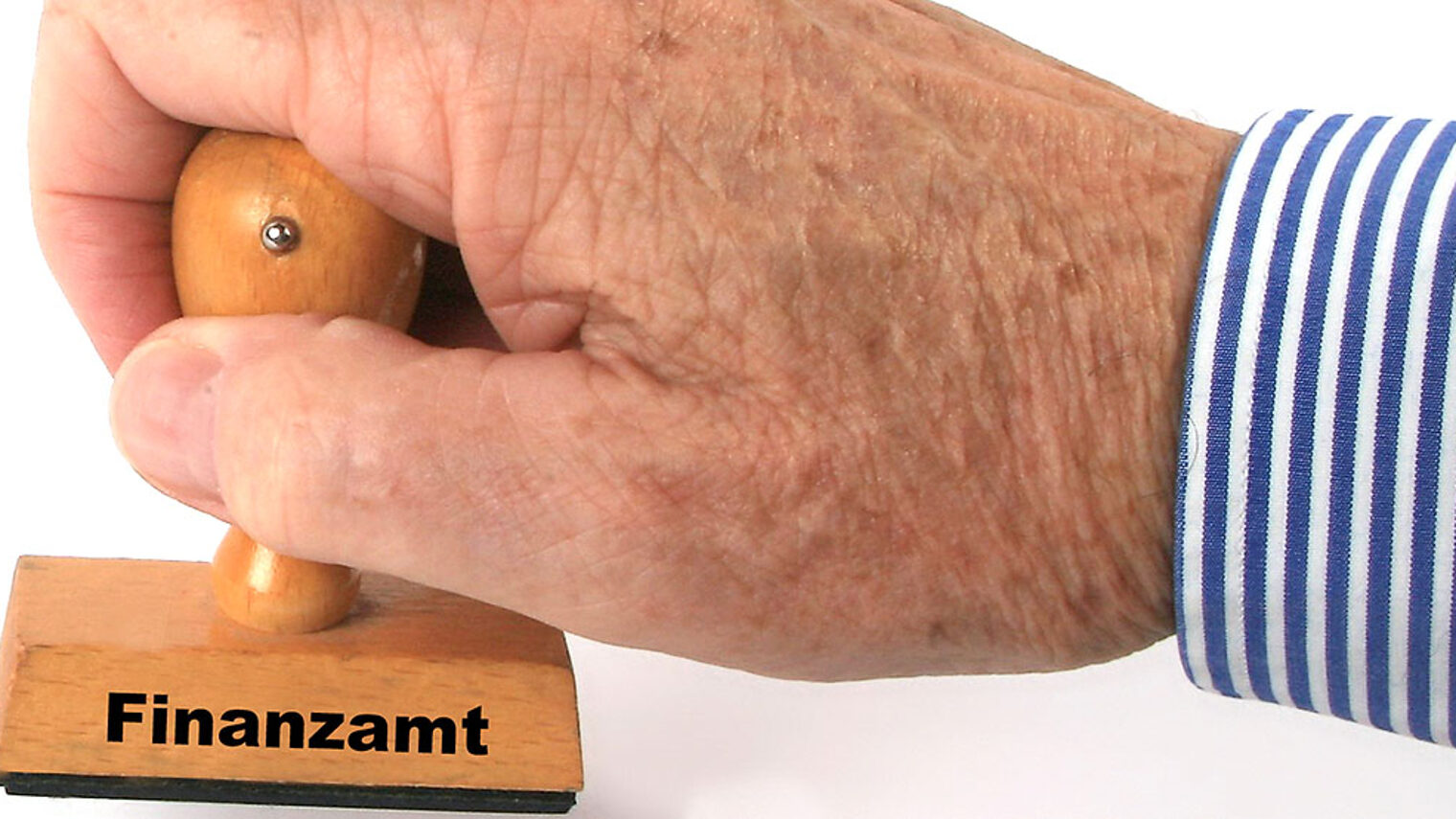 Eine Hand hält einen Stempel mit Aufdruck "Finanzamt".