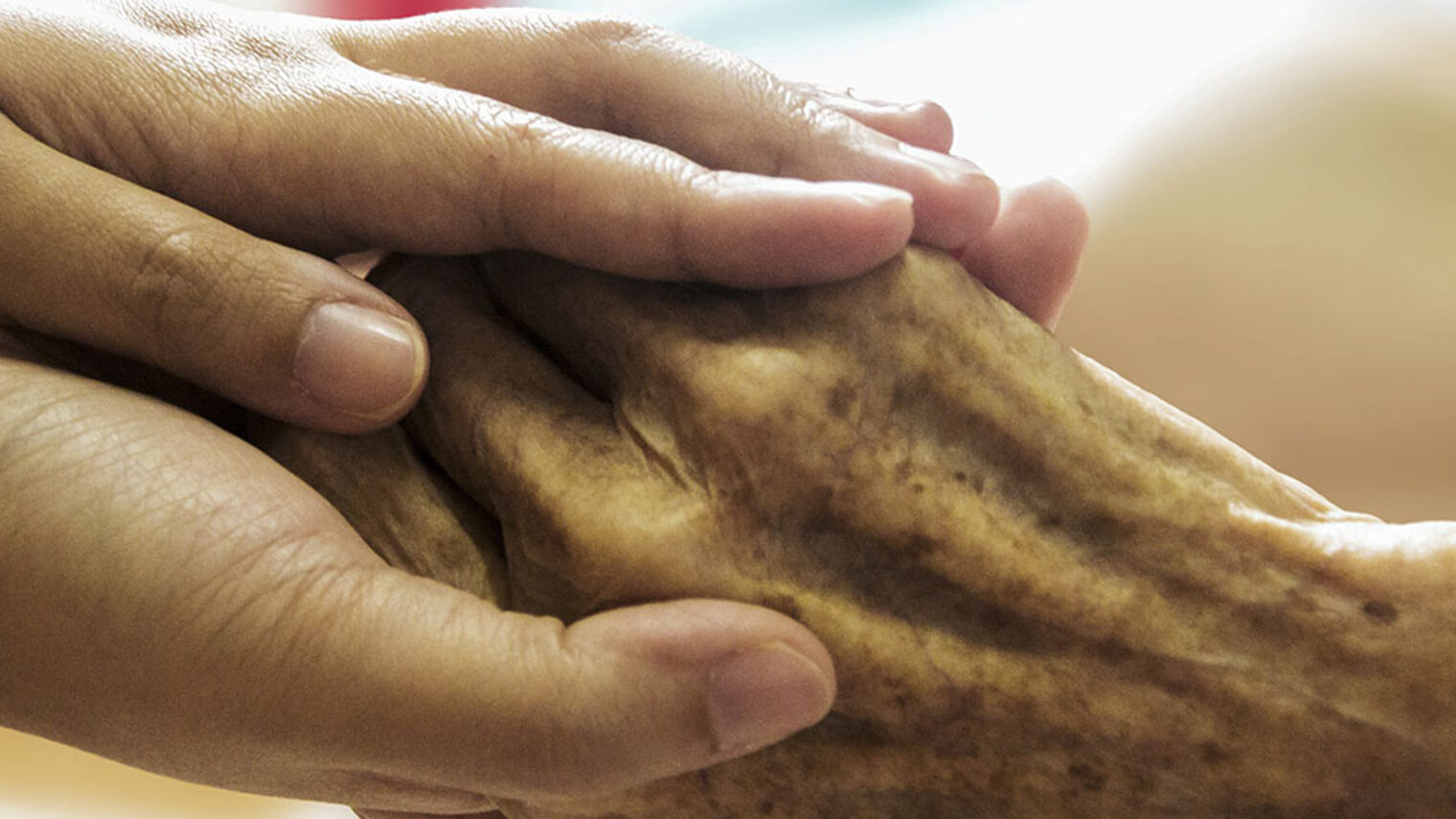 Eine Hand wird von zwei Händen umschlossen.